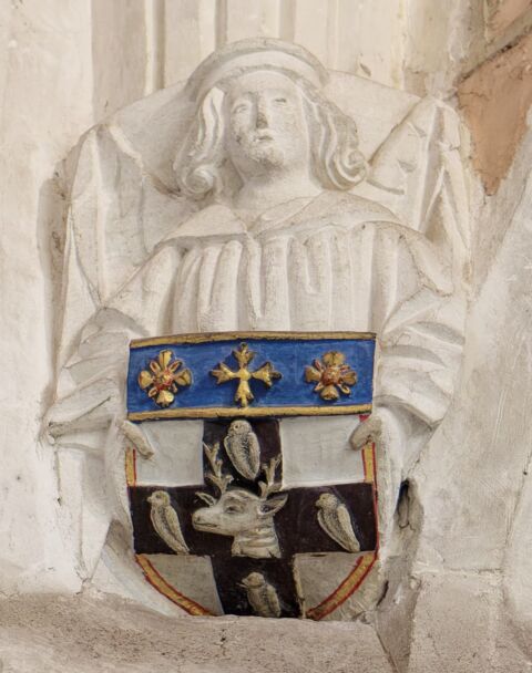A view of a carved angel corbel holding a shield bearing an unknown coat of arms