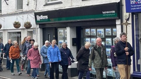 A picture showing the Good Friday walk of witness around the streets of Ottery, led by the cross