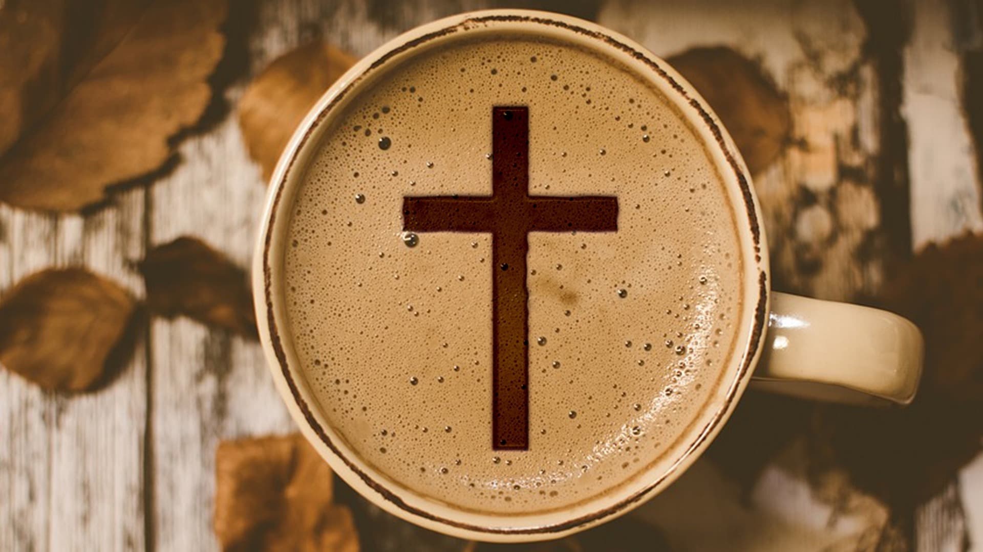 Photo of a cup of coffee with a cross in the foam