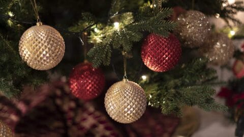 A picture of baubles hanging on a Christmas tree