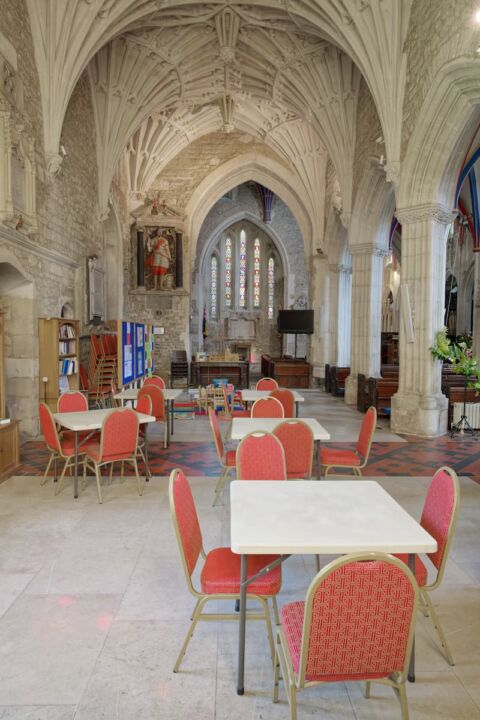 A view of the Dorset Aisle in Ottery St Mary church with tables and chairs laid out and children's area at the end