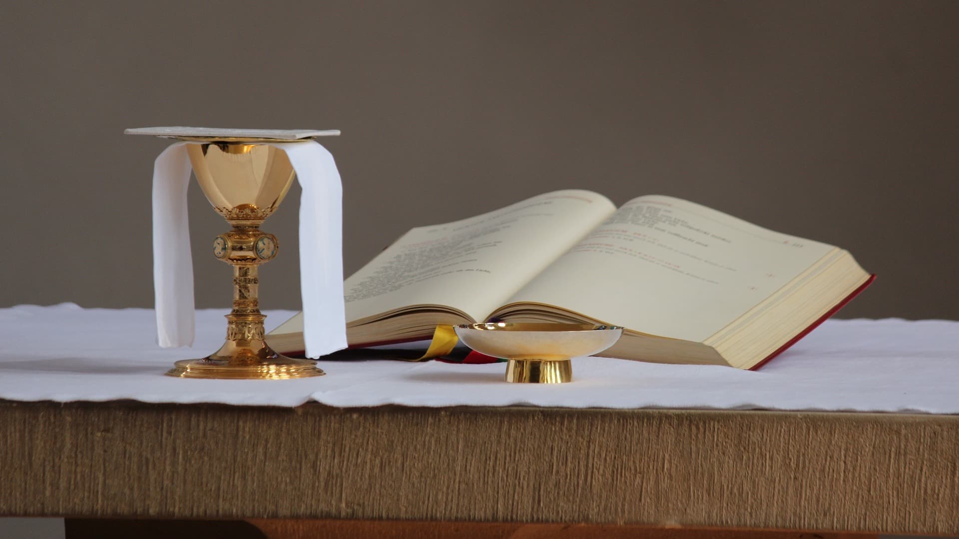 Photo of an open bible with a communion chalice and wafer