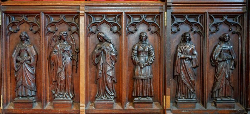 A view of the right side of the screen in Newton Poppleford church showing carved ladies from the Bible