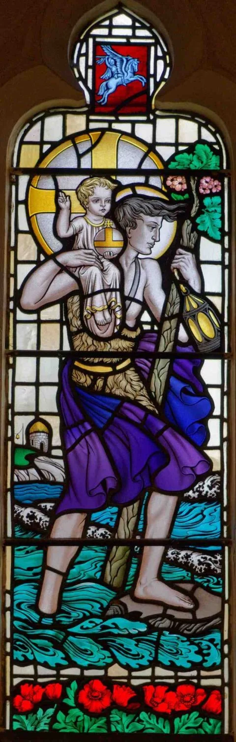 A stained glass window in Newton Poppleford church depicting John the Baptist carrying the infant Christ