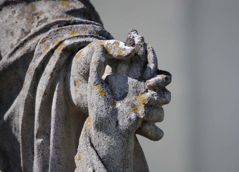 A statue in a churchyard of a parent holding a child's hand