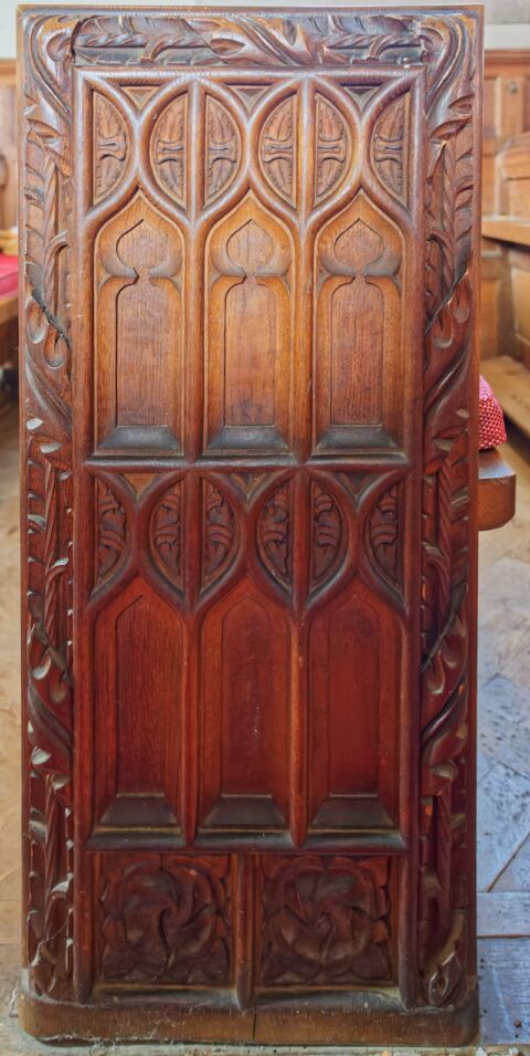 A view of an ornate carved pew end at Payhembury church