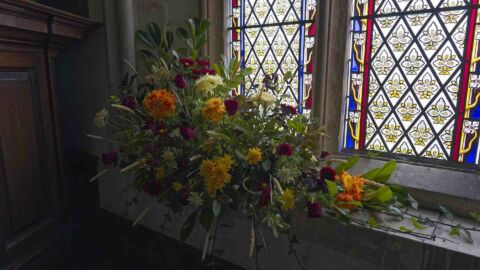 A photo of a flower arrangement in a window at Payhembury church