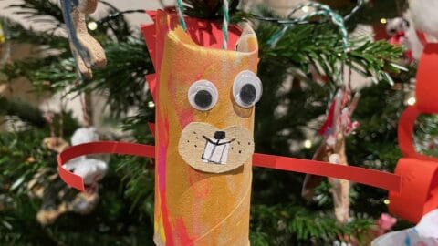 A picture of a child's hand made Christmas tree decoration in the shape of a squirrel with two goggly eyes