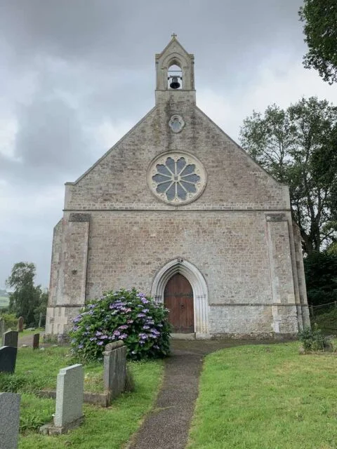 A view of the west end of Tipton St John church in the summer