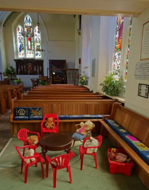 A view of the children's area in Tipton St John church with small chairs and cuddly toys