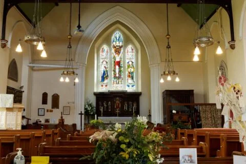 A view inside Tipton St John church looking east down the nave at the altar and east window