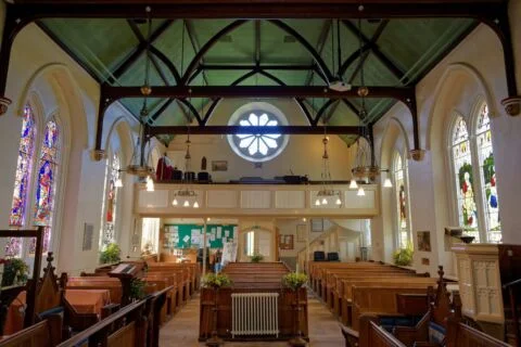 A view in Tipton St John church looking west down the nave at the gallery and west window