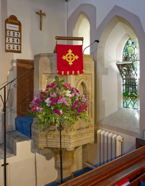 A view of the West Hill church stone pulpit with flower arrangement in front